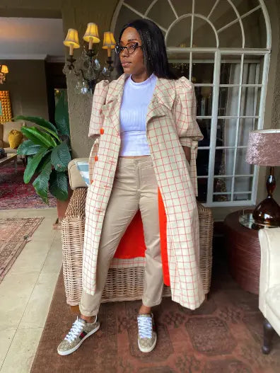 Cream plaid long trench coat with puff sleeves, open front and belt tie, side view