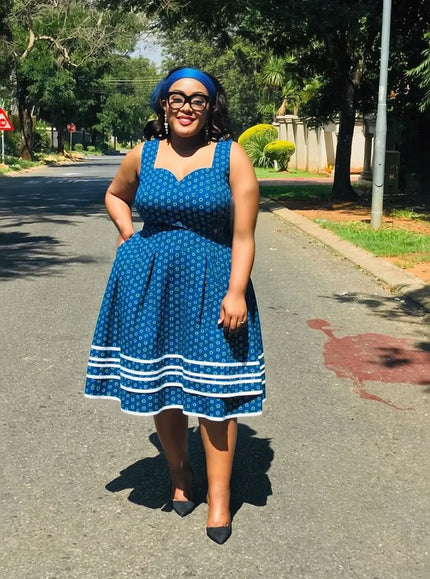 Sleeveless A-line mini dress with blue ethnic print and white hem trim