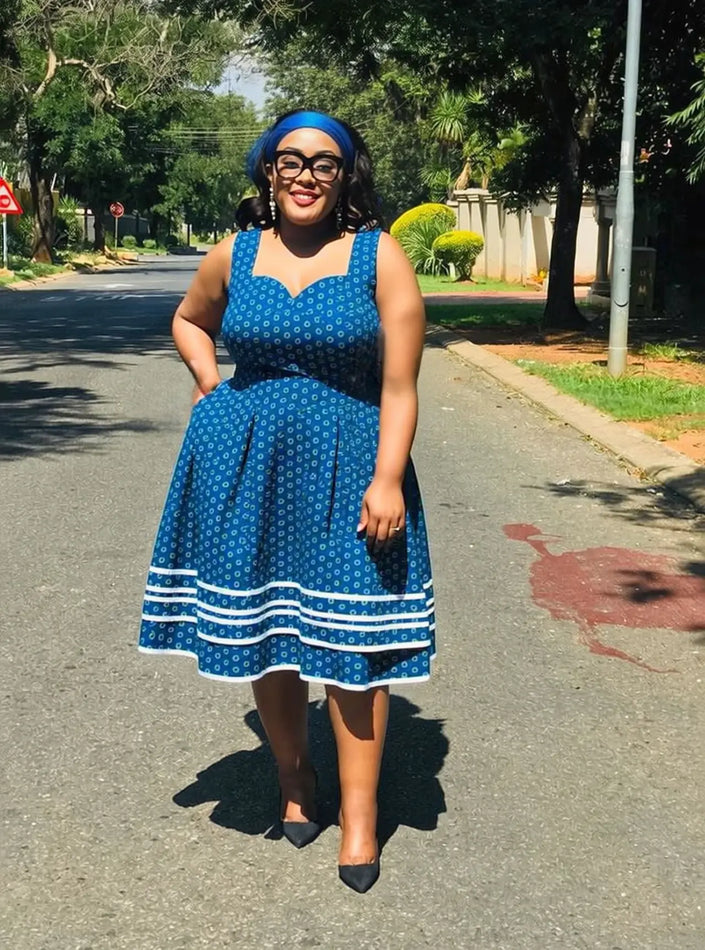 Sleeveless A-line mini dress with blue ethnic print and white hem trim