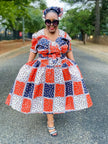 Geometric midi dress with puff sleeves, patchwork squares in red, blue, and white