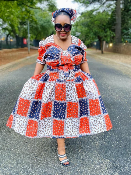 Geometric midi dress with puff sleeves, patchwork squares in red, blue, and white