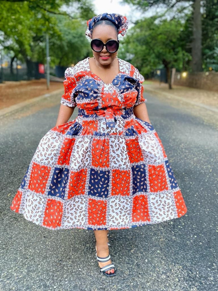 Geometric midi dress with puff sleeves, patchwork squares in red, blue, and white