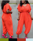 Orange-red cinched-waist jumpsuit with drawstring, loose wide legs, ankle cuffs
