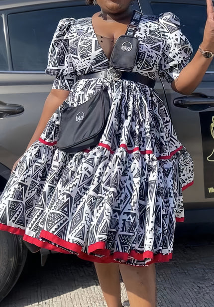 Geometric midi dress with puff sleeves, black-and-white pattern, red trim hem
