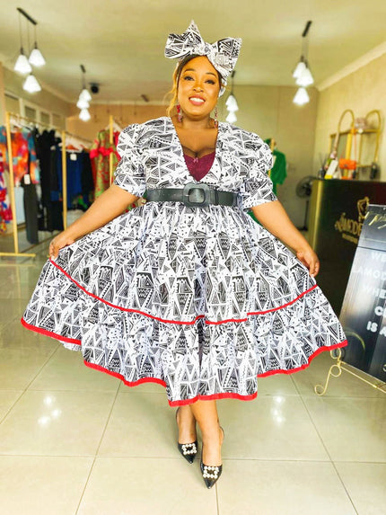 Geometric midi dress with puff sleeves, black-and-white pattern, red trim, bow belt