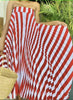 Off-shoulder pleated midi dress with red-and-white striped wave pattern