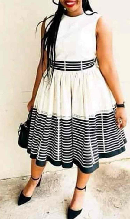 Sleeveless striped dress with flared skirt, black waist band, white and black stripes