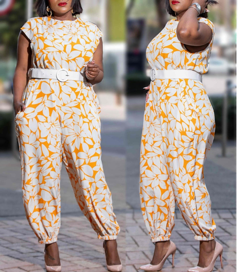 Belted floral jumpsuit with cap sleeves, white base and orange leaf pattern, ankle cuffs