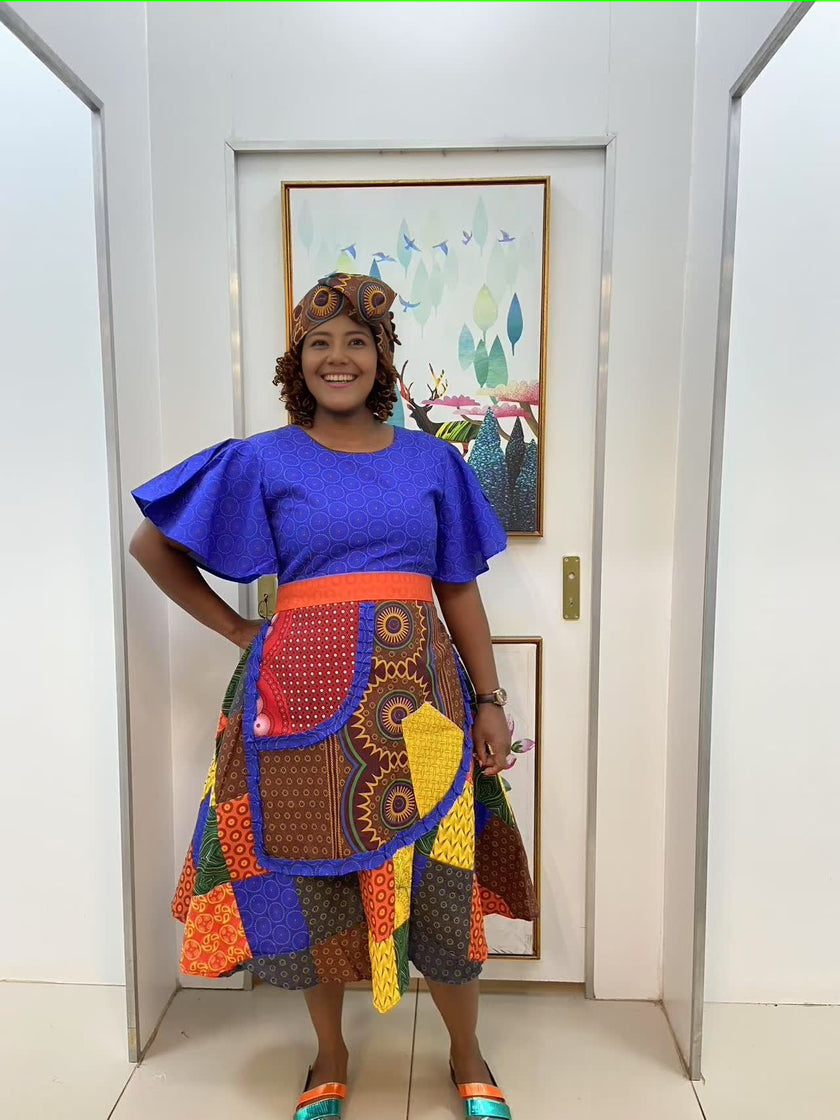 Blue puff-sleeve midi dress with multicolor patchwork skirt and curved orange waist band