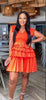 Orange-red pleated layered mini dress with belted waist and tiered ruffle skirt