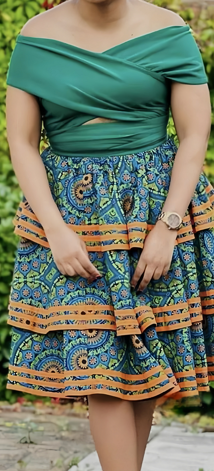 Off-shoulder patchwork dress with teal bodice, geo floral skirt, waist tie