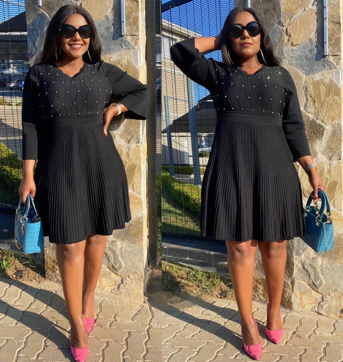 Black knit pleated dress with V-neck and long sleeves