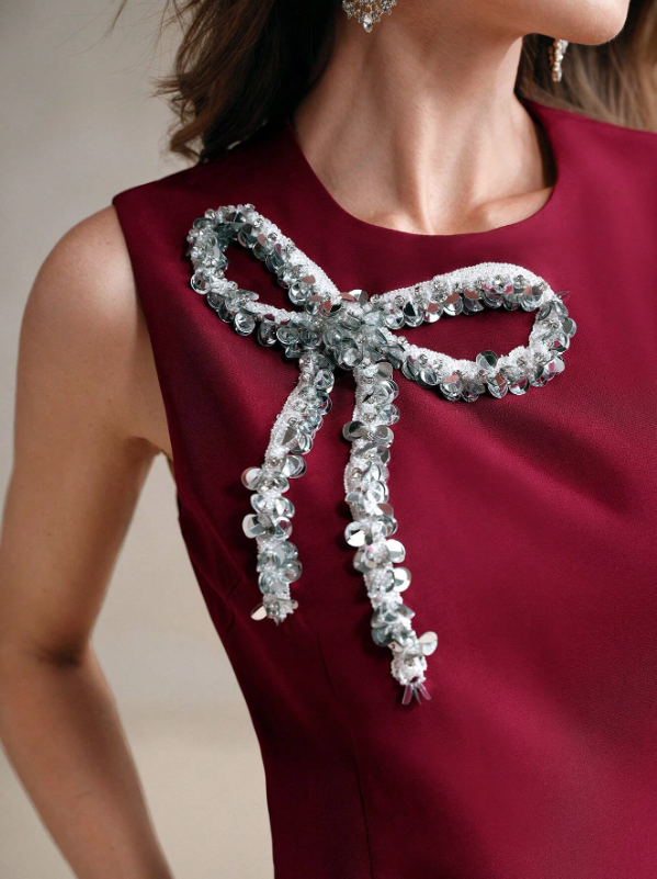 Maroon sleeveless mini dress close-up: crystal bow applique at front