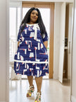 Plus size blue midi dress with abstract white, red, and navy block print, tied neckline