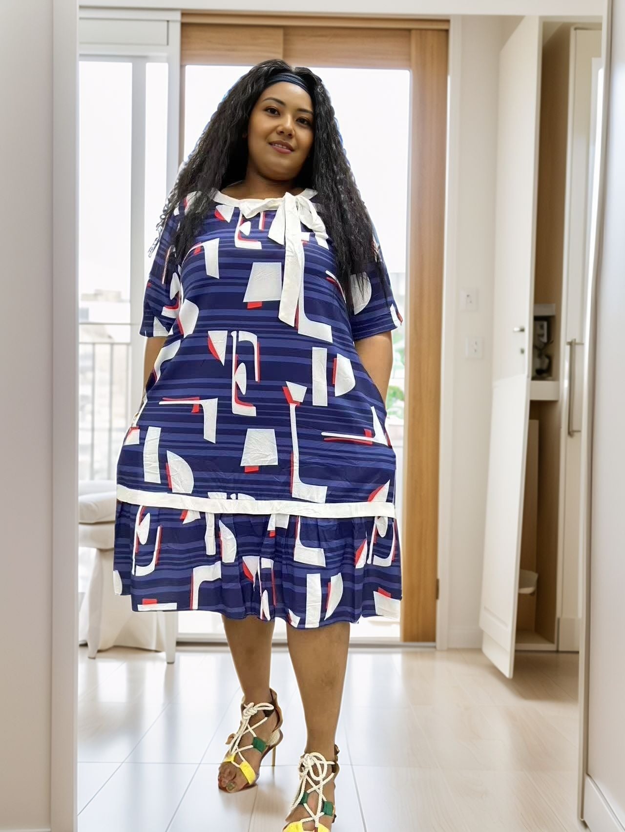 Plus size blue midi dress with abstract white, red, and navy block print, tied neckline