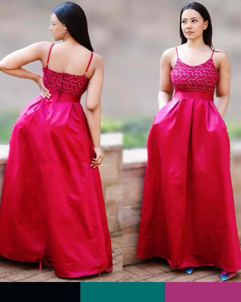Red maxi dress with thin straps, patterned corset bodice, and full pleated skirt