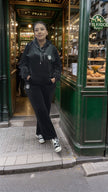 Dark zip-up hoodie and jogger pants set with chest logo and drawstring hood