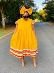 Plus size flared sleeve dress, yellow with pleated full skirt and rainbow striped hem