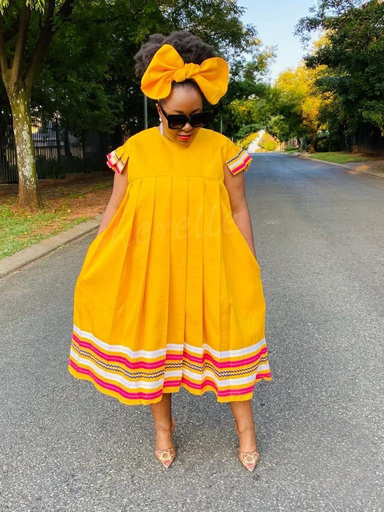 Plus size flared sleeve dress, yellow with pleated full skirt and rainbow striped hem