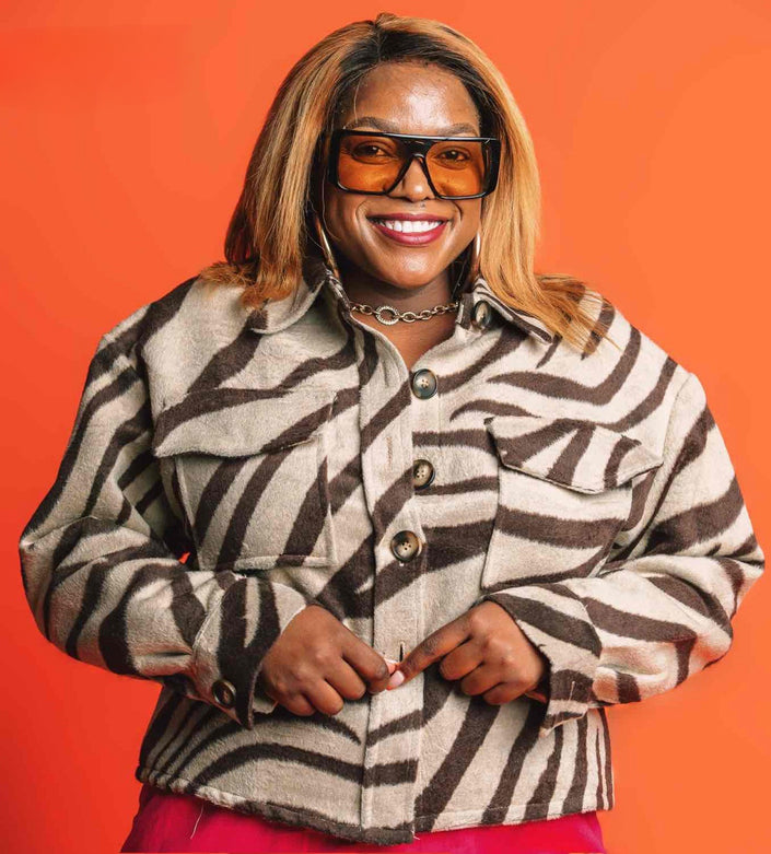 Zebra print jacket with long sleeves, button front, stand collar, and chest pockets