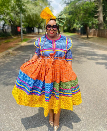 Geometric print dress with yellow headwrap, tiered ruffle skirt and colorful striped yoke