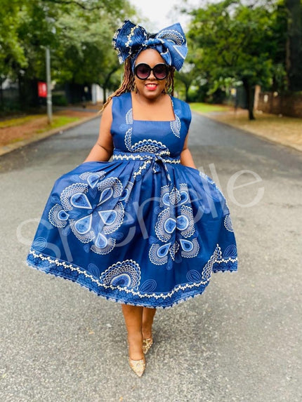 Blue printed A-line skirt dress with white floral motifs and ruffled skirt.
