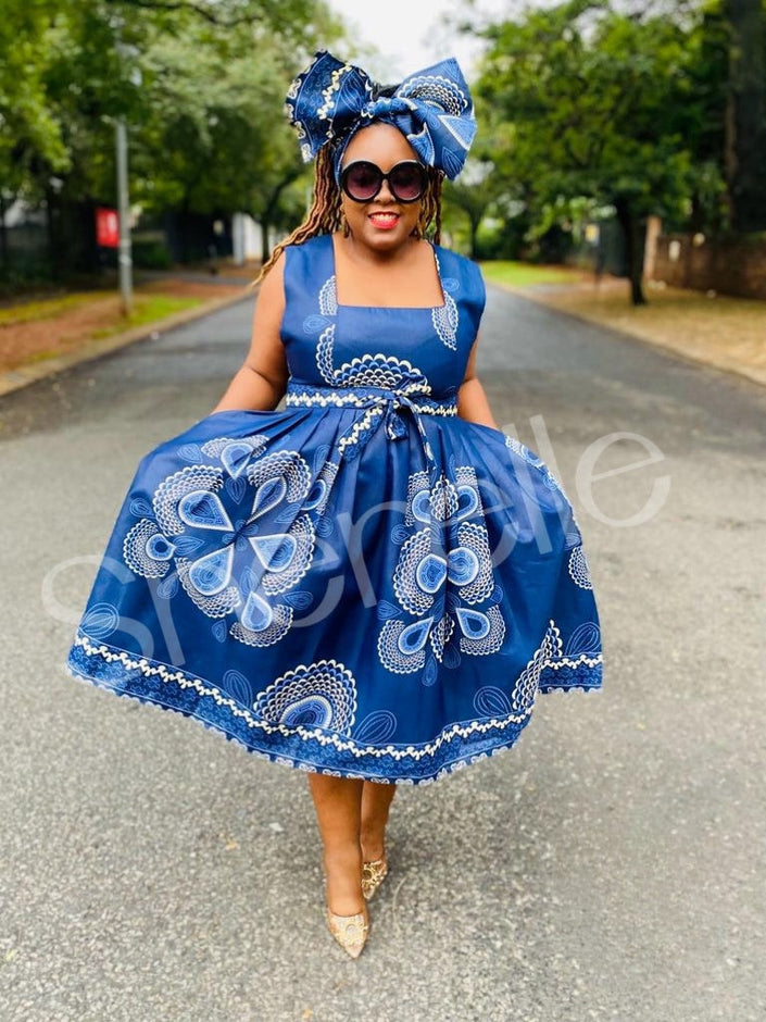 Blue printed A-line skirt dress with white floral motifs and ruffled skirt.