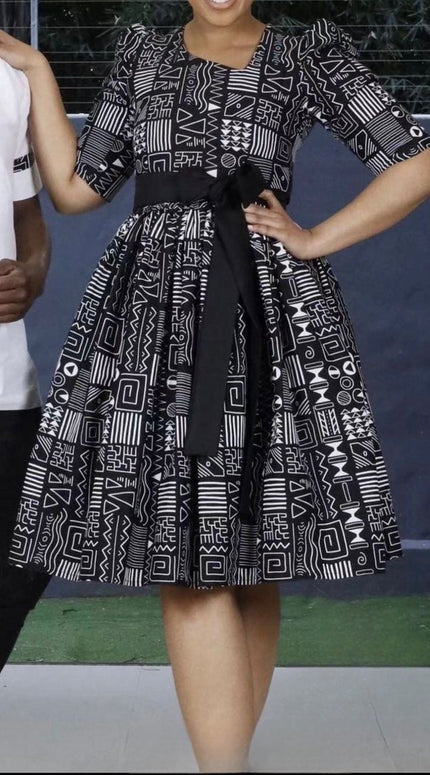 Geometric midi dress with black belt and long puff sleeves, round neckline