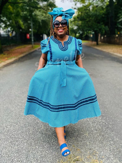 Blue shweshwe-style dress with puff sleeves and flared skirt