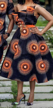 Off-shoulder African print dress in dark navy with orange medallions and belted waist