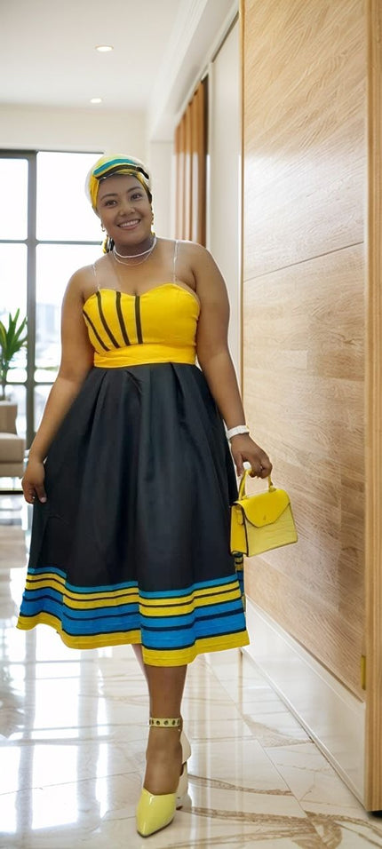 Midi patchwork A-line dress with yellow bodice and black skirt, blue striped hem.