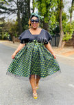 V-neck geometric skirt dress with bow waist, dark bodice and green patterned skirt