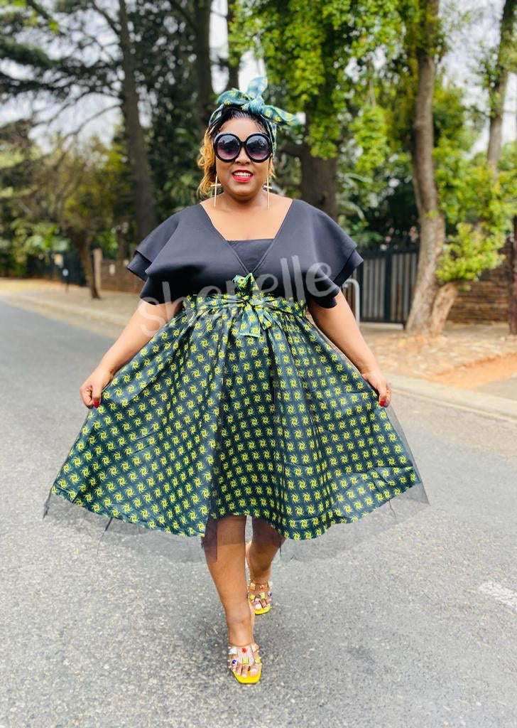 V-neck geometric skirt dress with bow waist, dark bodice and green patterned skirt