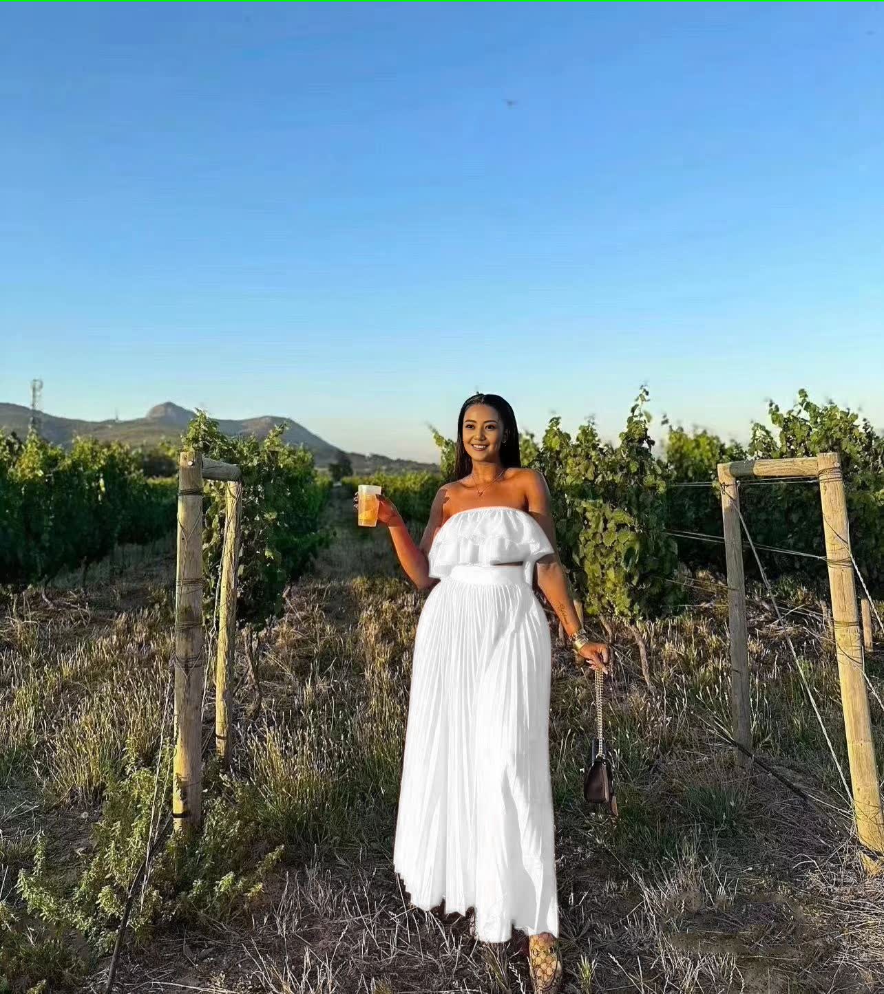 Off-shoulder white maxi dress with ruffle trim at bust and tiered skirt