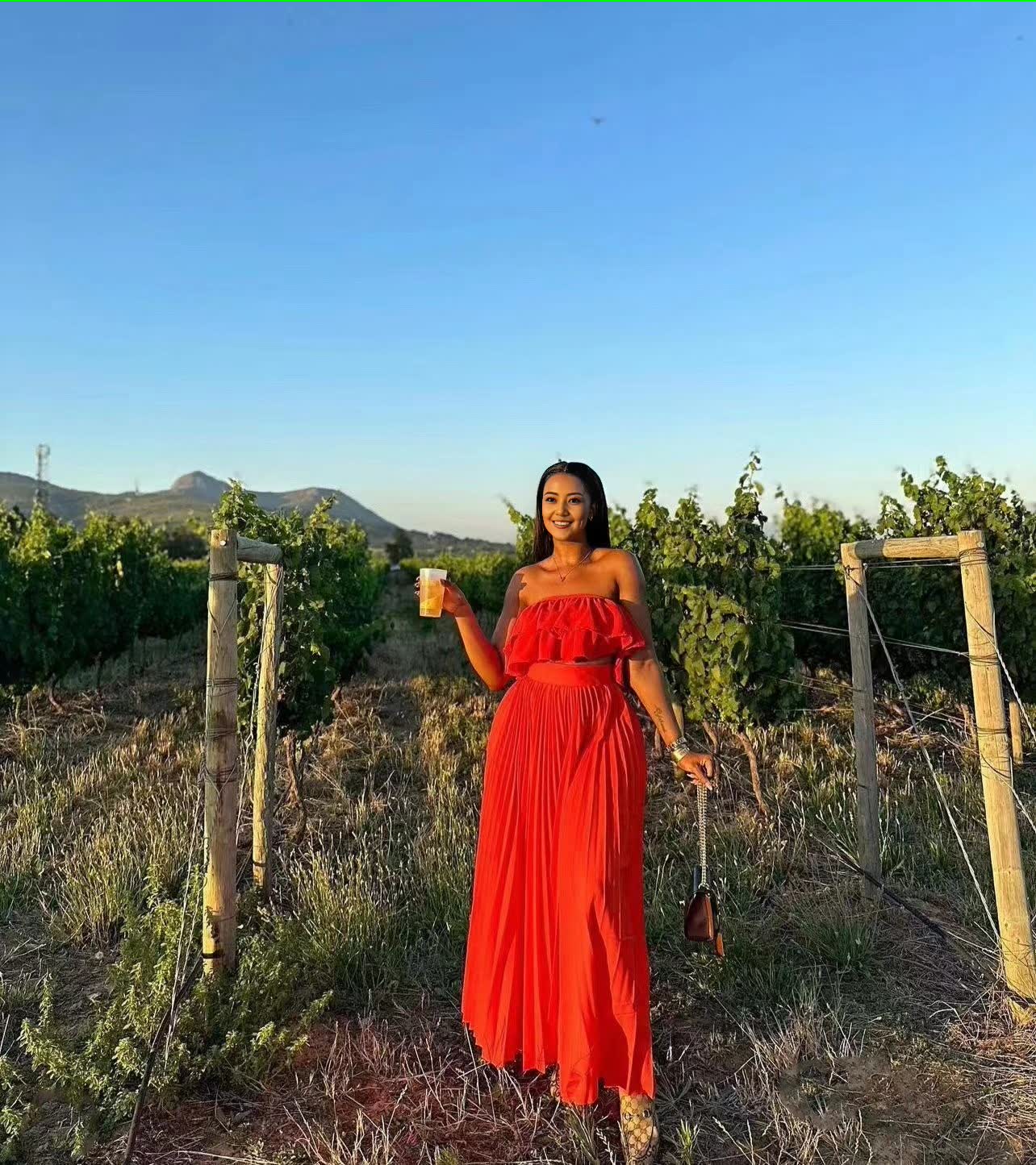Off-shoulder red maxi dress with ruffle trim at bust and tiered skirt