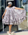 Plus size flared lace dress with puff sleeves, tiered skirt, light pattern.