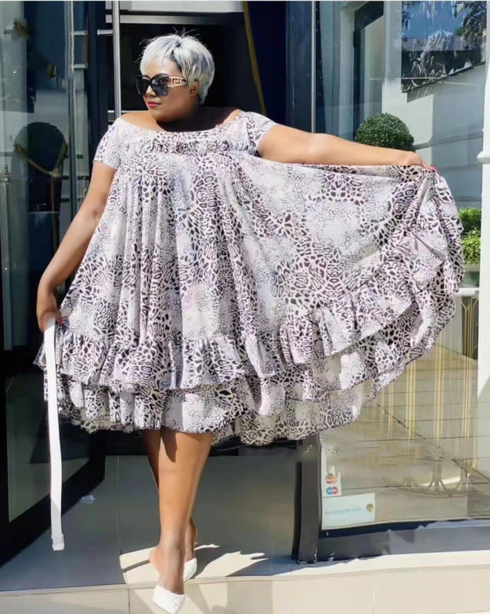 Plus size flared lace dress with puff sleeves, tiered skirt, light pattern.