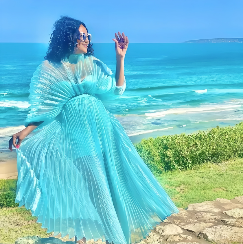 Sky-blue pleated maxi dress with cinched waist and flowing tiered skirt