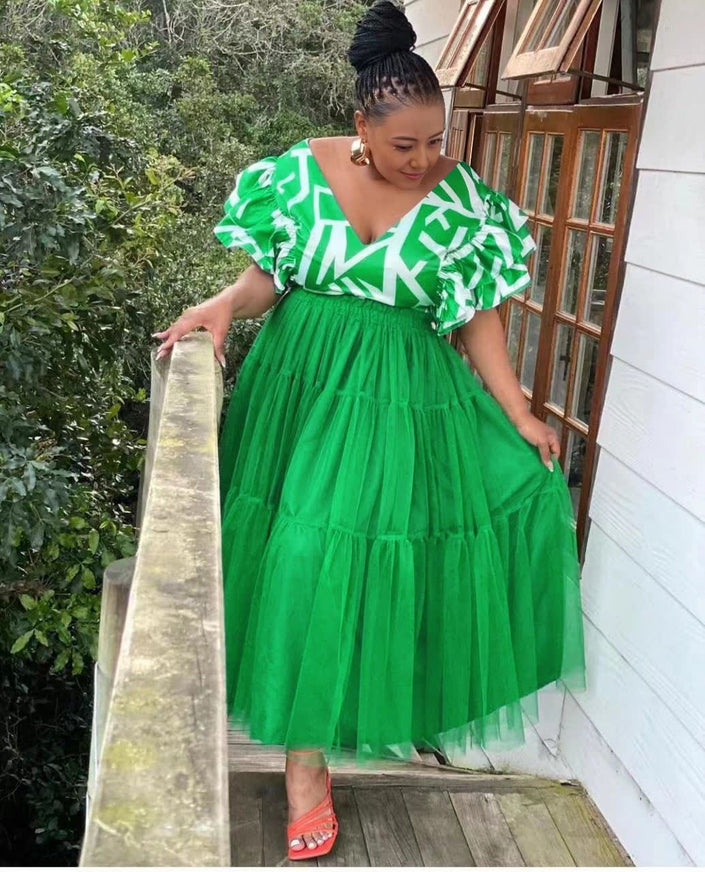 Bright green tiered tulle maxi dress with ruffled puff sleeves and white pattern bodice
