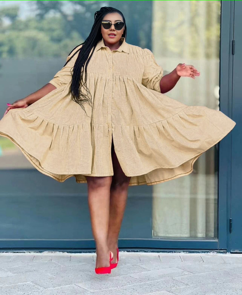 Cream ruffle-hem shirt dress with long sleeves and button-front, tiered flared skirt.