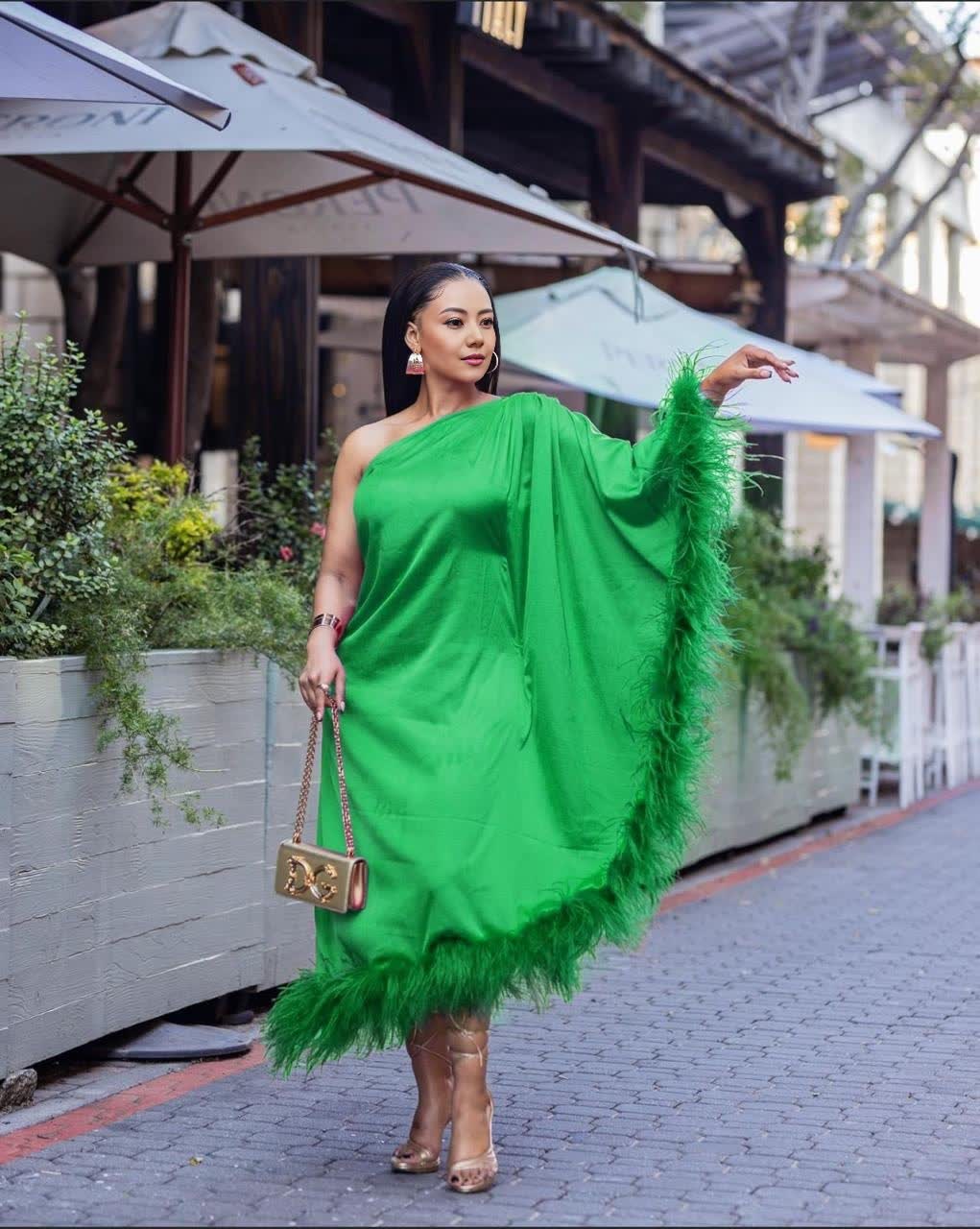 One-shoulder evening dress in lime green satin, with feather trim at hem.