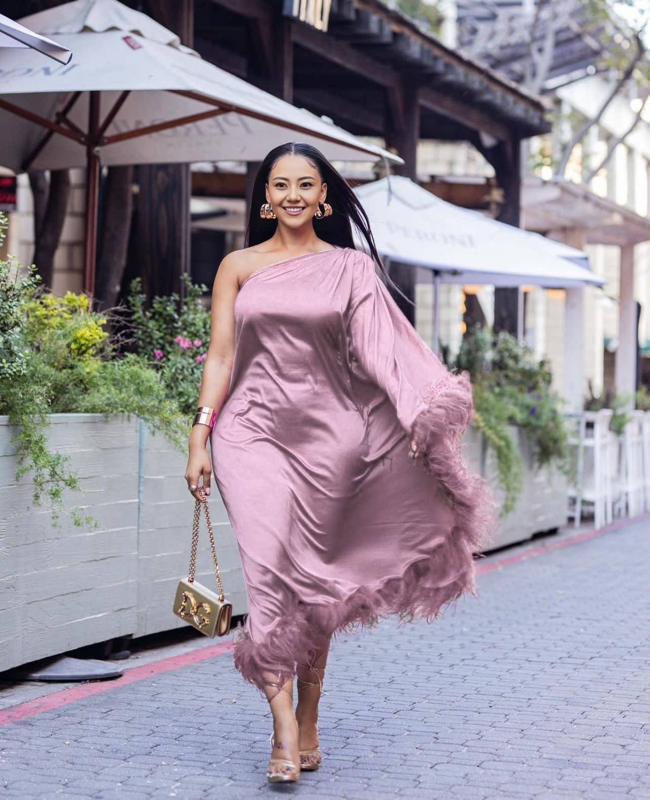 One-shoulder evening dress in mauve satin, with feather trim at hem.