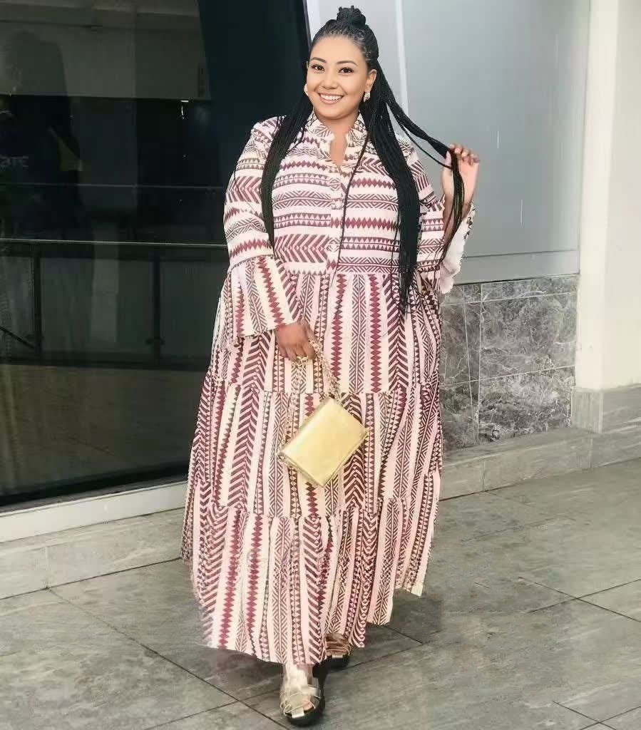 Plus size geometric tiered maxi dress with long sleeves, maroon and white striped pattern.
