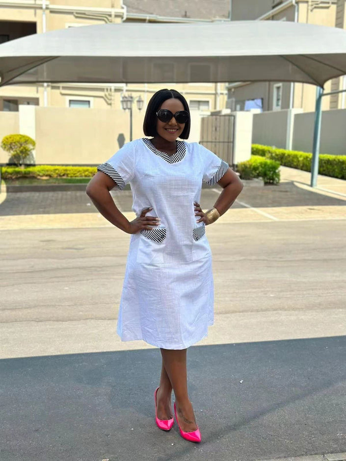 White plus size midi dress with short sleeves and patterned pocket accents