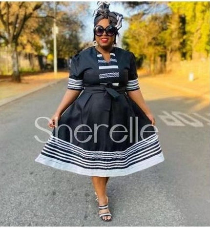 Black midi shirt dress with striped cuffs, striped hem, and tied belt