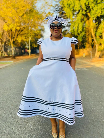 White midi dress with ruffle sleeves, striped hem and full skirt
