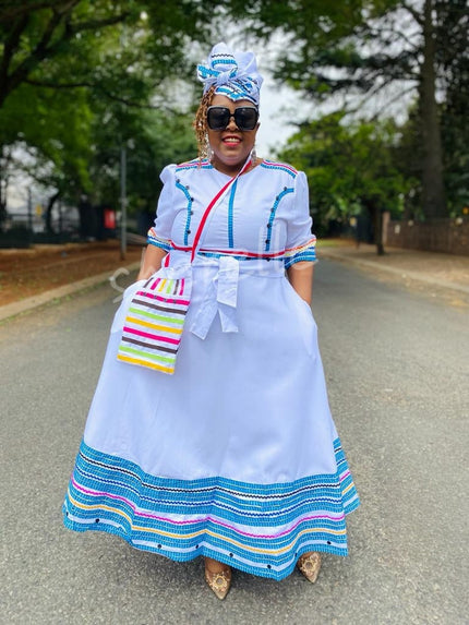 White geometric beaded midi dress with multicolor striped hem and bow-tie waist bag