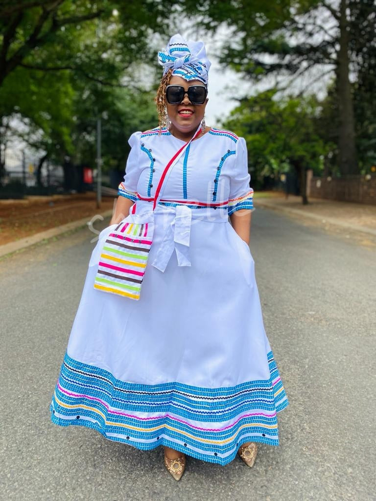 White geometric beaded midi dress with multicolor striped hem and bow-tie waist bag