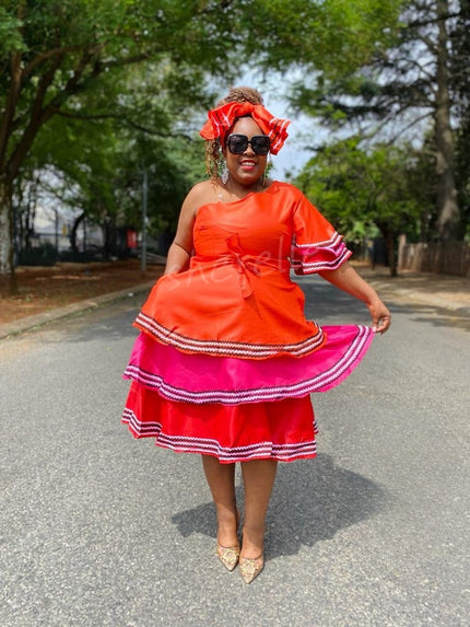Orange sleeveless ruffle dress with layered skirt and striped trim, midi length