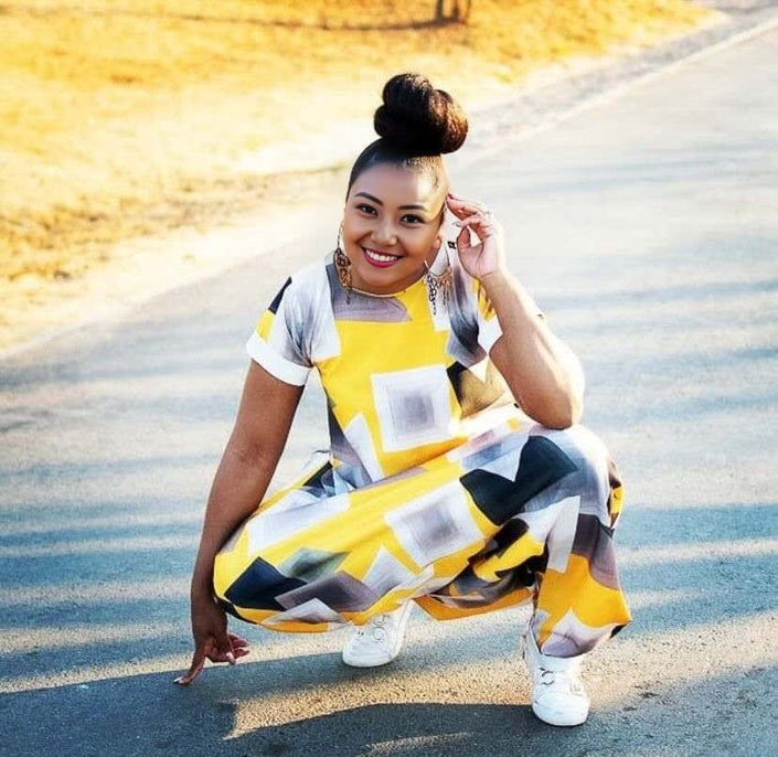 Geometric loose-fit jumpsuit with yellow and navy square blocks, short sleeves, sneakers